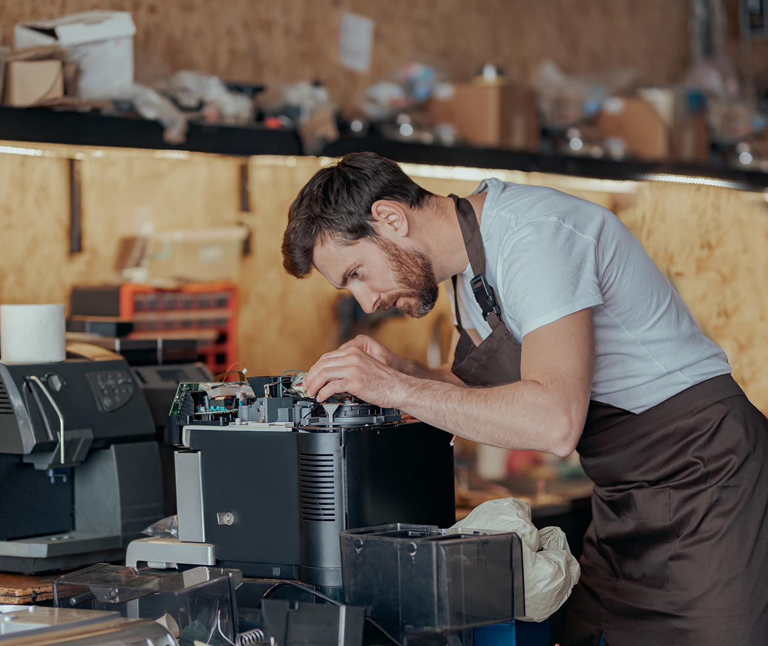 Man worker repair a coffee machine in own workshop
