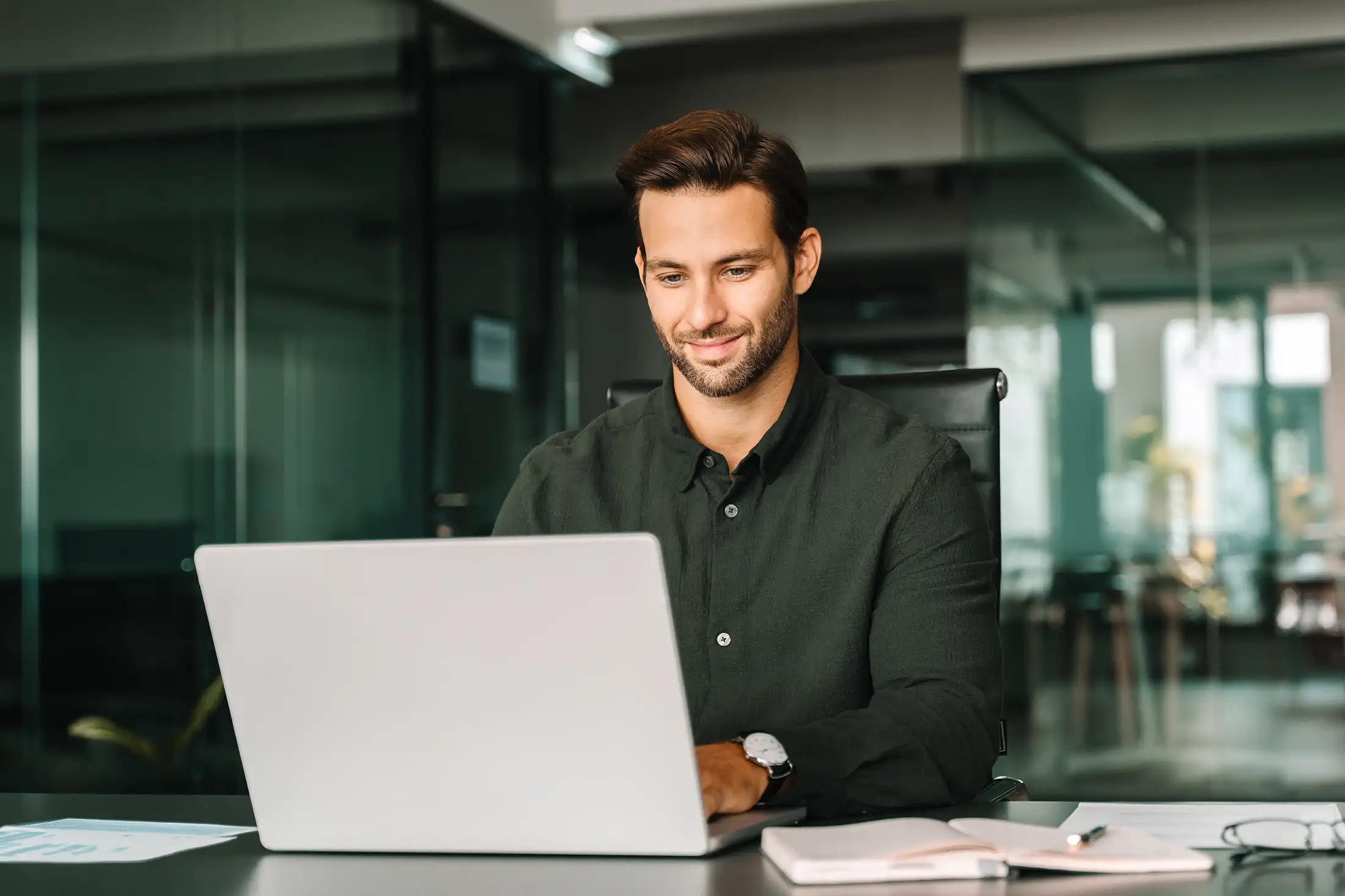 man working on laptop computer in company office